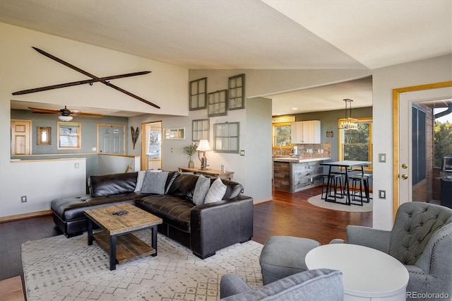 living room featuring ceiling fan, wood-type flooring, and vaulted ceiling