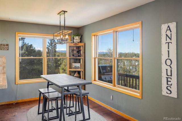 dining area featuring dark hardwood / wood-style flooring and an inviting chandelier