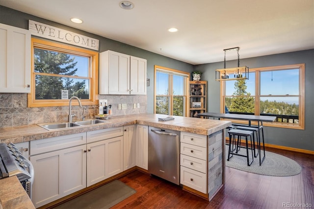 kitchen with white cabinetry, sink, dark hardwood / wood-style flooring, decorative light fixtures, and appliances with stainless steel finishes