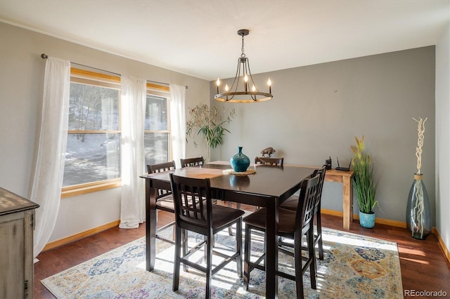 dining area featuring dark wood-type flooring and a notable chandelier