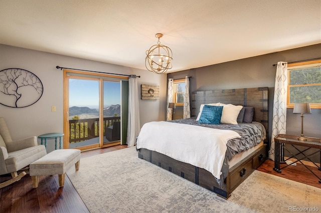 bedroom featuring access to exterior, a mountain view, a chandelier, and hardwood / wood-style flooring