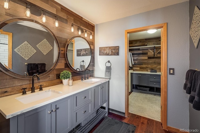 bathroom with wood-type flooring, vanity, and wooden walls