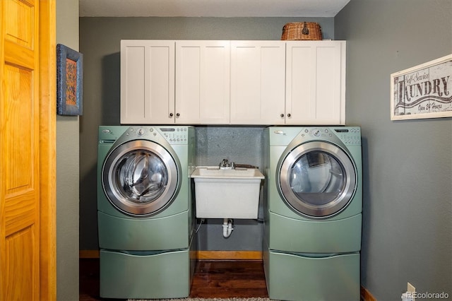 laundry room with washer and clothes dryer, cabinets, sink, and hardwood / wood-style flooring