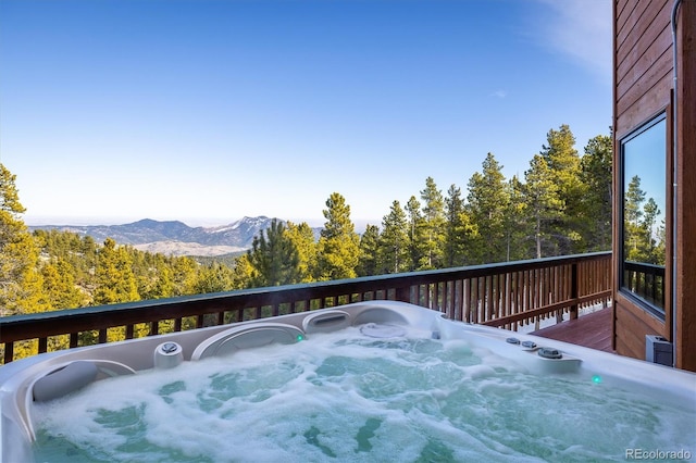 deck featuring a mountain view and a hot tub