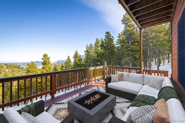 deck featuring an outdoor living space with a fire pit