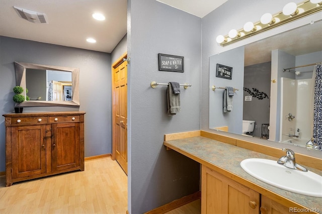 full bathroom with shower / bath combo, toilet, wood-type flooring, and vanity