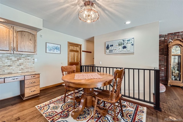 dining space featuring dark wood-type flooring and built in desk