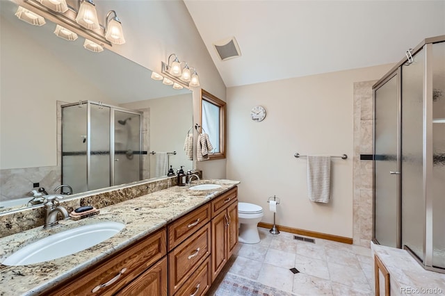 bathroom featuring a shower with door, vaulted ceiling, and vanity