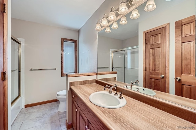 full bathroom featuring vanity, combined bath / shower with glass door, tile patterned floors, and toilet