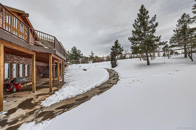 yard layered in snow with a wooden deck