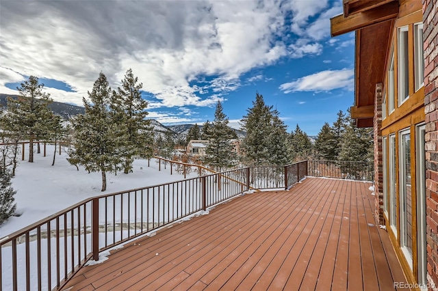 snow covered deck featuring a mountain view