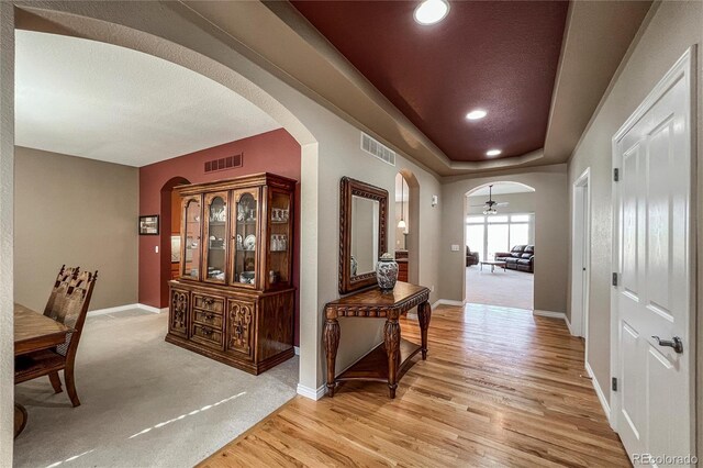 1430 Bluefield Ave, Longmont, CO 80504 - hallway featuring arched walkways, light wood-type flooring, visible vents, and baseboards