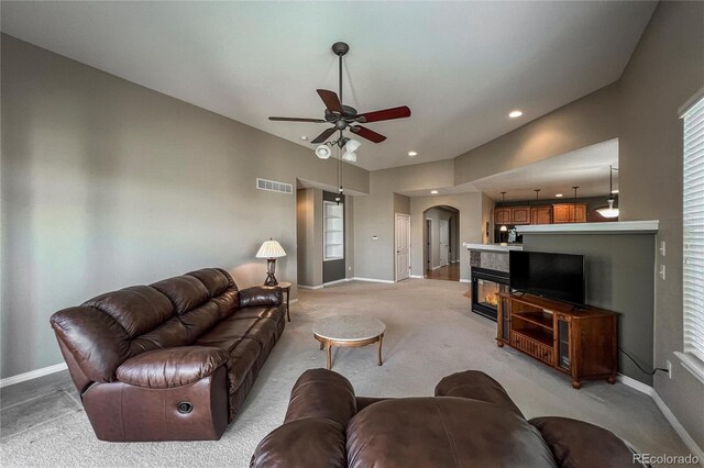 1430 Bluefield Ave, Longmont, CO 80504 - living area featuring light carpet, a ceiling fan, baseboards, and arched walkways