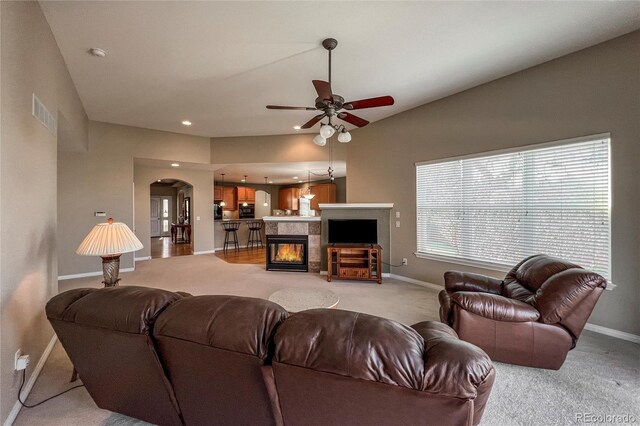 1430 Bluefield Ave, Longmont, CO 80504 - living area featuring a tiled fireplace, a ceiling fan, baseboards, and light colored carpet