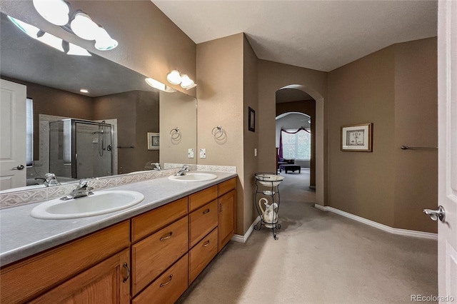 1430 Bluefield Ave, Longmont, CO 80504 - bathroom with baseboards, a sink, double vanity, and a stall shower