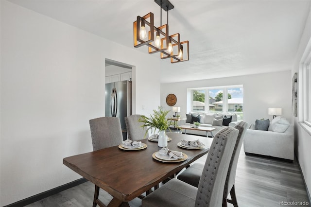 1973 Bahama St, Aurora, CO 80011 - dining space featuring wood finished floors, a chandelier, and baseboards