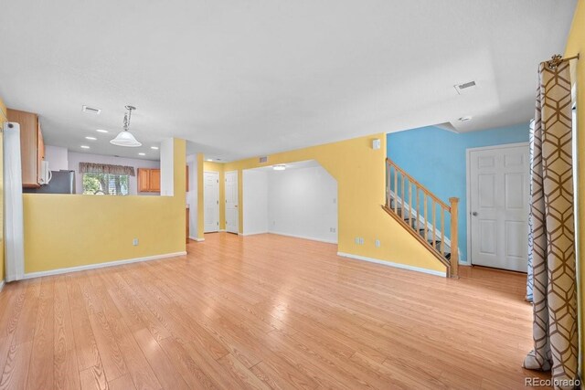 426 Plowman Way, Fort Collins, CO 80526 - unfurnished living room with stairway and light wood-style floors