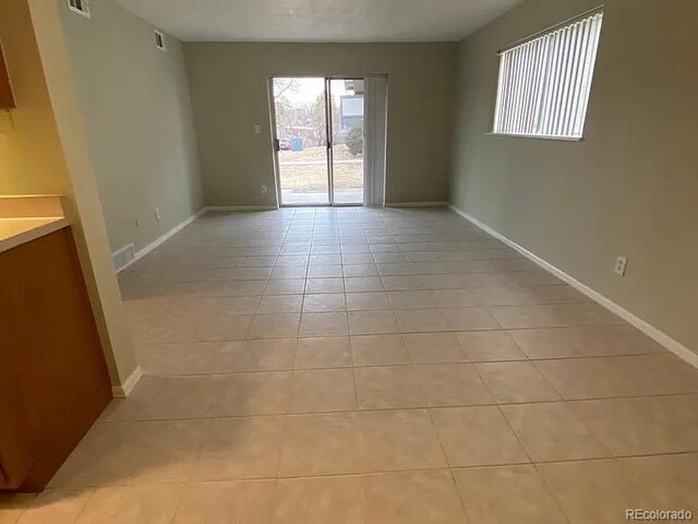 100 E Highline Cir Unit 105, Centennial, CO 80122 - spare room featuring light tile patterned floors and baseboards