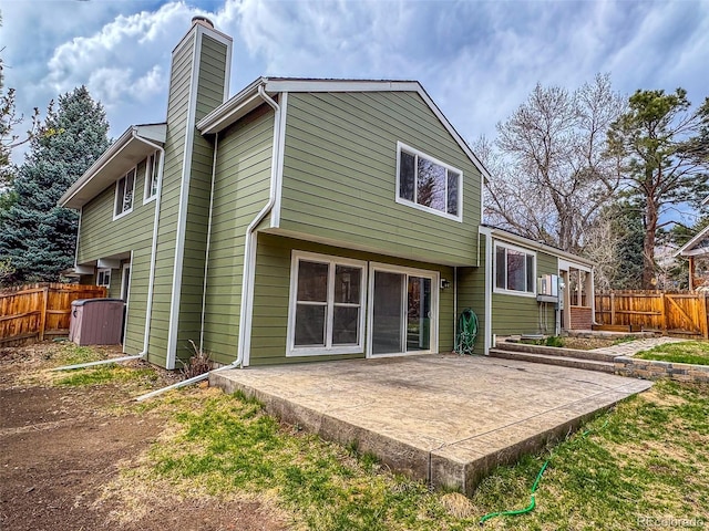 6640 S Heritage Pl W, Centennial, CO 80111 - back of property featuring cooling unit, a patio, a chimney, and fence