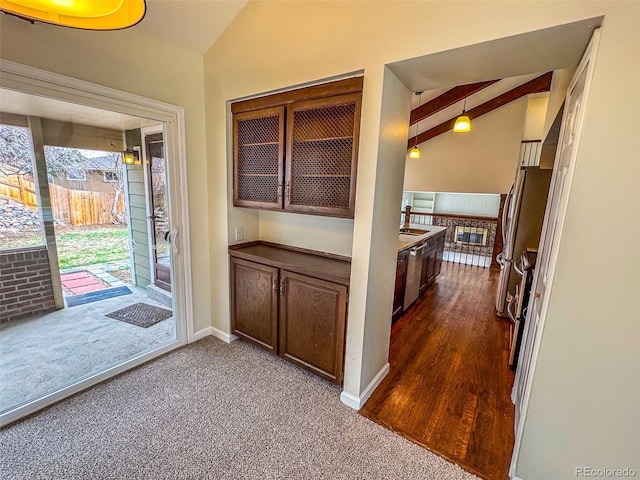 6640 S Heritage Pl W, Centennial, CO 80111 - kitchen featuring lofted ceiling with beams, dark colored carpet, a sink, stainless steel appliances, and baseboards