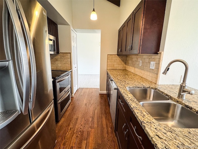 6640 S Heritage Pl W, Centennial, CO 80111 - kitchen featuring light stone counters, dark brown cabinets, dark wood finished floors, stainless steel appliances, and a sink