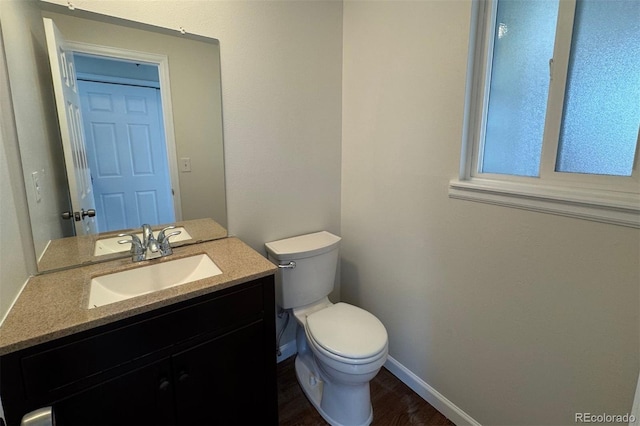 6640 S Heritage Pl W, Centennial, CO 80111 - bathroom featuring toilet, vanity, wood finished floors, and baseboards