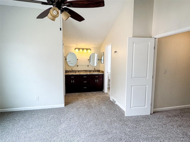6640 S Heritage Pl W, Centennial, CO 80111 - unfurnished bedroom featuring ensuite bathroom, a textured ceiling, light carpet, lofted ceiling, and baseboards