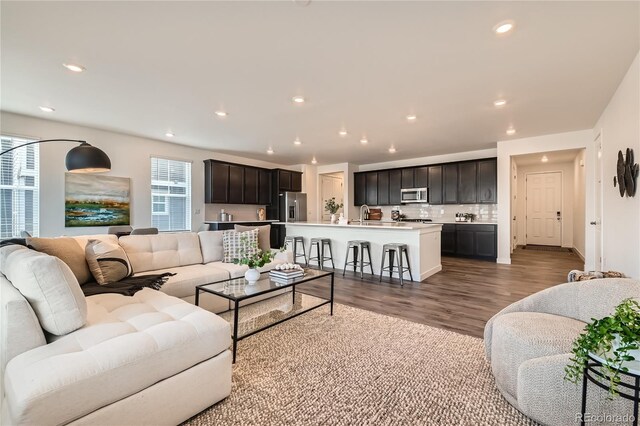 living room with dark wood-style flooring and recessed lighting