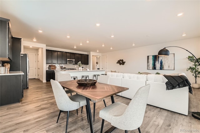 dining room with light wood-type flooring and recessed lighting