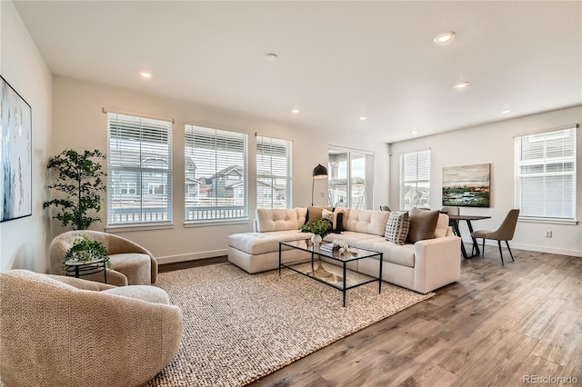 living room with baseboards, wood finished floors, and recessed lighting