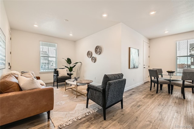 living room with a healthy amount of sunlight, light wood-style floors, and baseboards