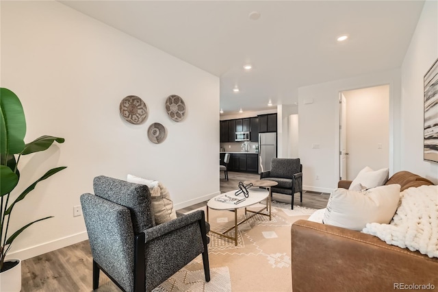 living room featuring baseboards, wood finished floors, and recessed lighting