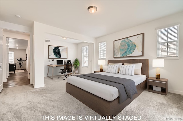 bedroom featuring baseboards, visible vents, and light colored carpet