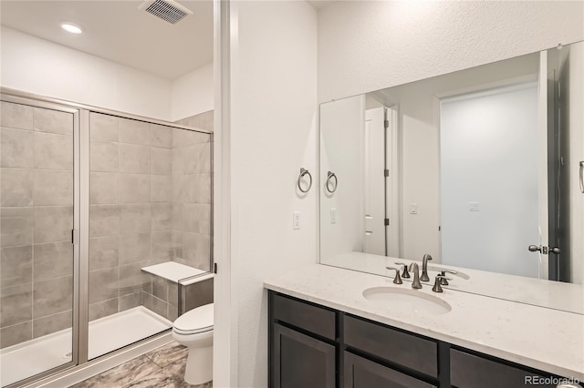 bathroom featuring toilet, a stall shower, visible vents, and vanity