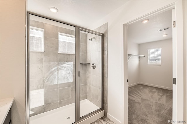 bathroom featuring a shower stall, visible vents, and baseboards