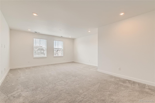 empty room featuring light carpet, recessed lighting, visible vents, and baseboards