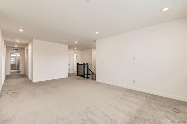 empty room with recessed lighting, light carpet, visible vents, and baseboards