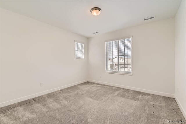 unfurnished room featuring light carpet, baseboards, and visible vents