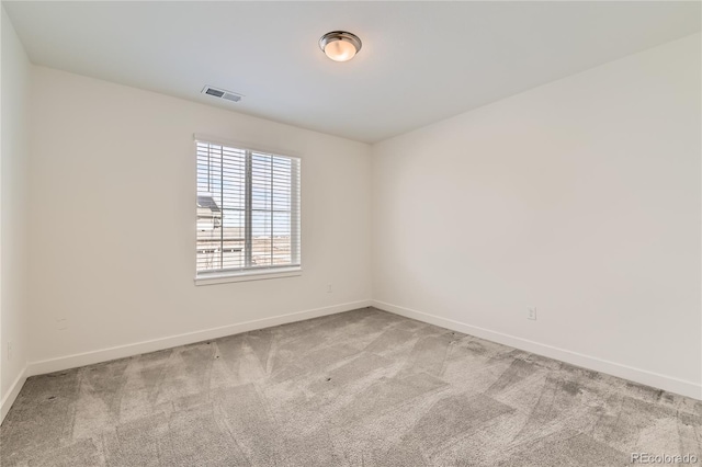 empty room featuring visible vents, light carpet, and baseboards