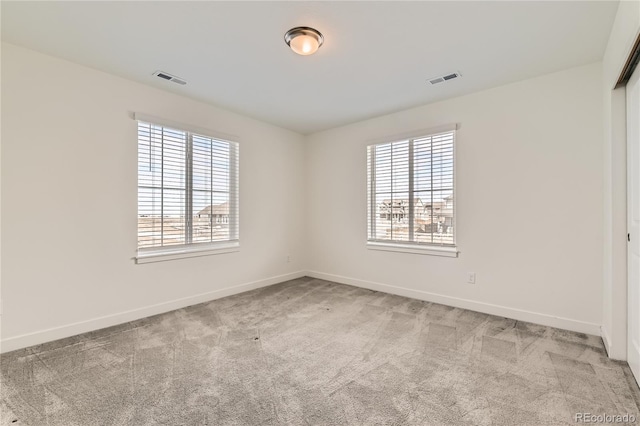 unfurnished room featuring carpet floors, a healthy amount of sunlight, and baseboards