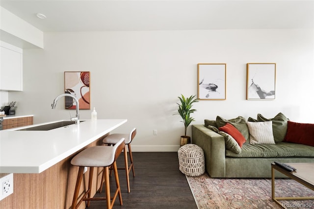 living room featuring dark wood-type flooring and baseboards