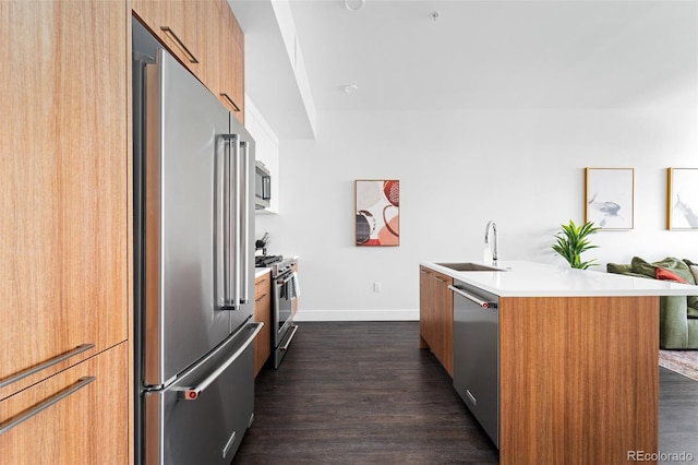 kitchen featuring dark wood-style floors, modern cabinets, a sink, and high quality appliances