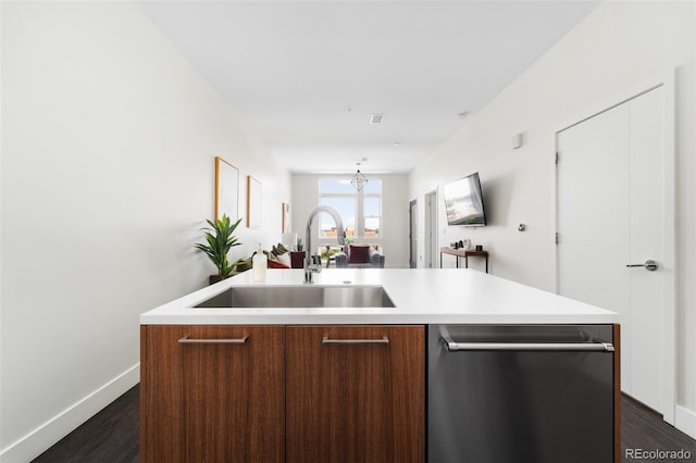 kitchen with a sink, dark wood finished floors, light countertops, and stainless steel dishwasher