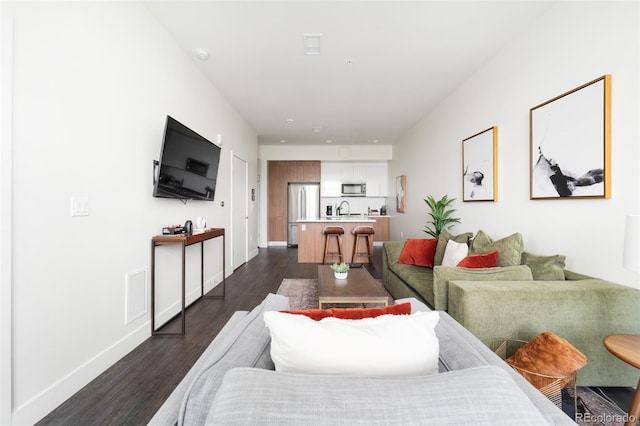 living room with visible vents, dark wood finished floors, and baseboards