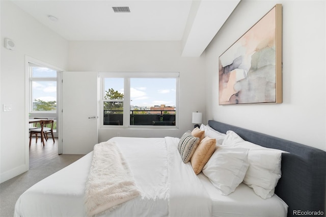 bedroom featuring visible vents, light carpet, and baseboards