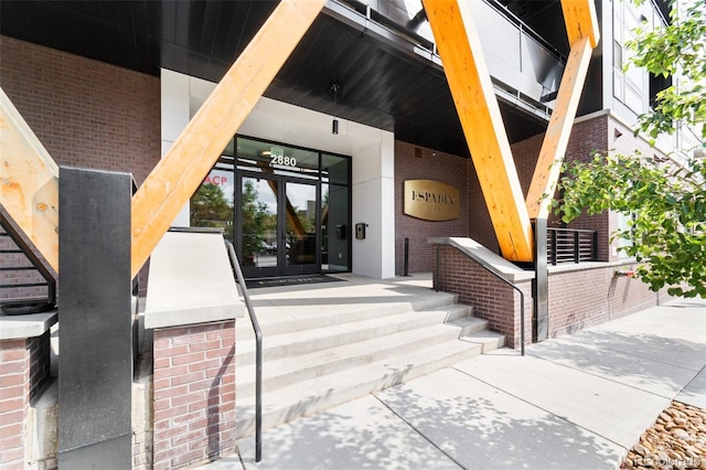 view of exterior entry with french doors and brick siding