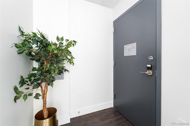 foyer entrance with dark wood-style floors and baseboards