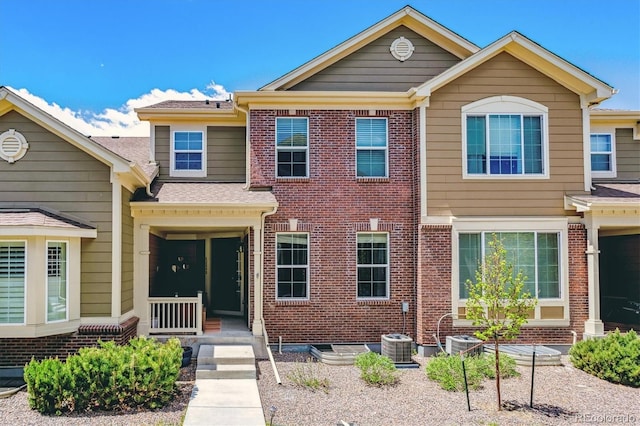 view of front of property featuring brick siding and central AC unit