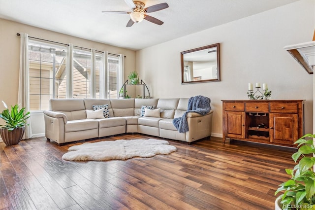 living area with dark wood-style floors, baseboards, and a ceiling fan