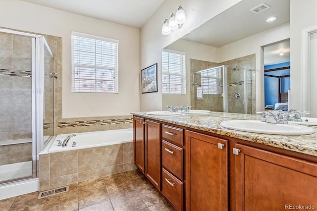 ensuite bathroom with double vanity, a stall shower, a garden tub, and visible vents
